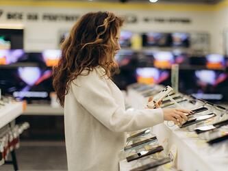 person looking at smartphones in an electronics shop